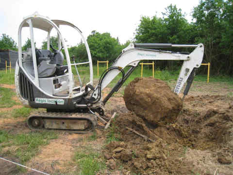 grosse pierre extraite du sol avec la mini-pelle